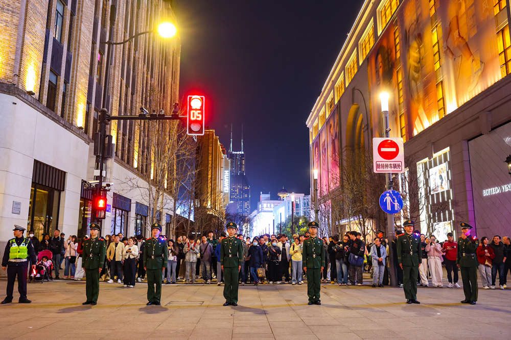 图片说明:武警官兵以“人墙”形式在重要路段疏导客流。陈昊 摄