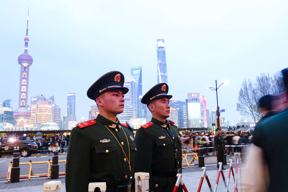 图片说明:武警官兵在重要路口设置“环岛”式双向隔离人墙,有效控制人流。陈昊摄