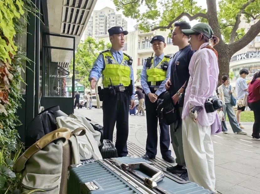 图为民警提醒摄影师、游客,拍摄时注意箱包安全