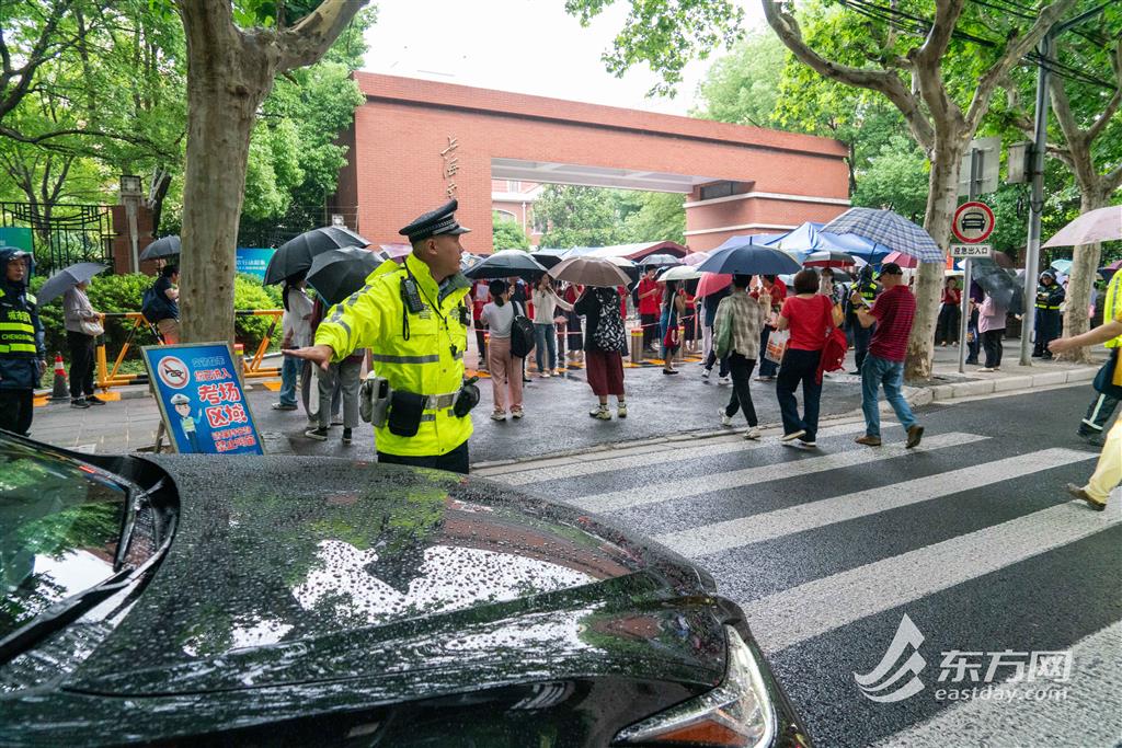 图为徐汇公安分局民警在考点学校路口疏导交通(蔡黄浩/摄)