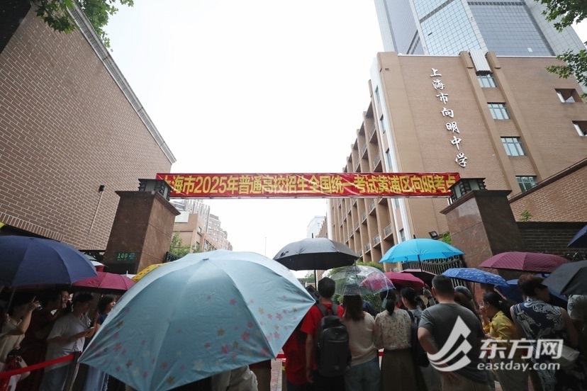 高考首日降雨,送考家长在向明中学高考考点目送考生入场(柏可林摄,下同)