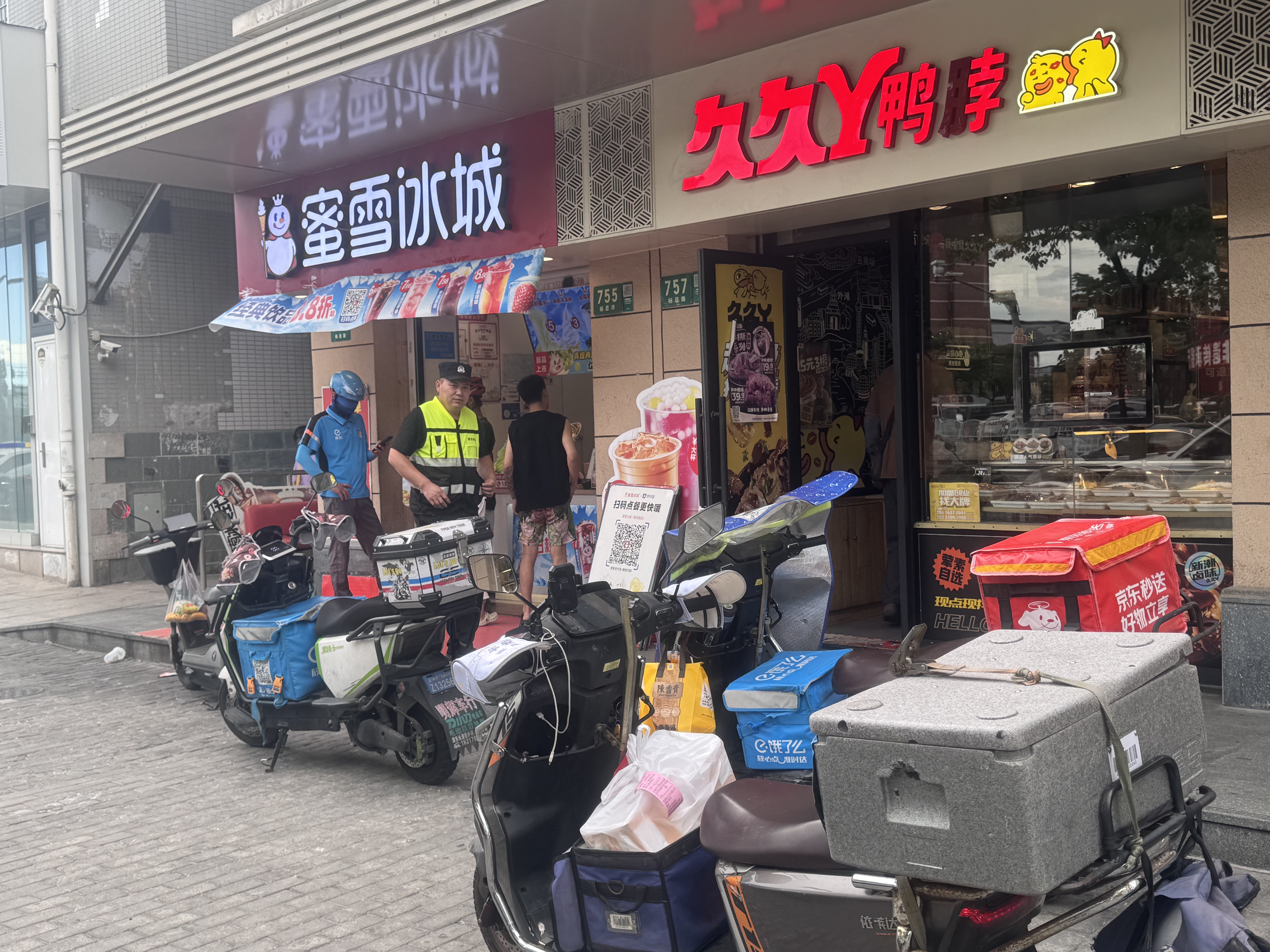 蜜雪冰城门口外卖小哥在等待取货,摄影 揭书宜