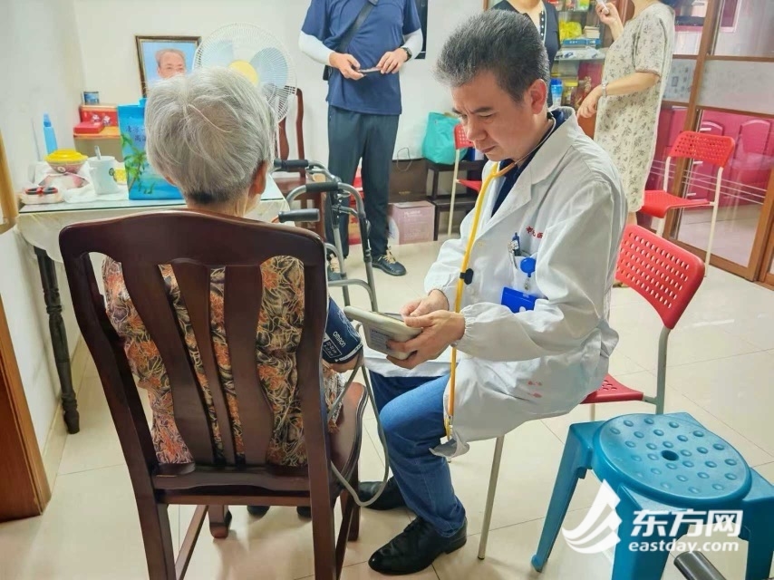 急诊内科党员朱荣斌医生来到91岁独居老人崔阿婆家,给老人量血压。张翔宇 摄
